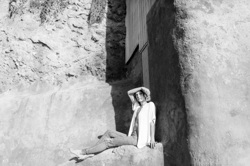 girl sitting on cliffs for laguna beach boudoir session