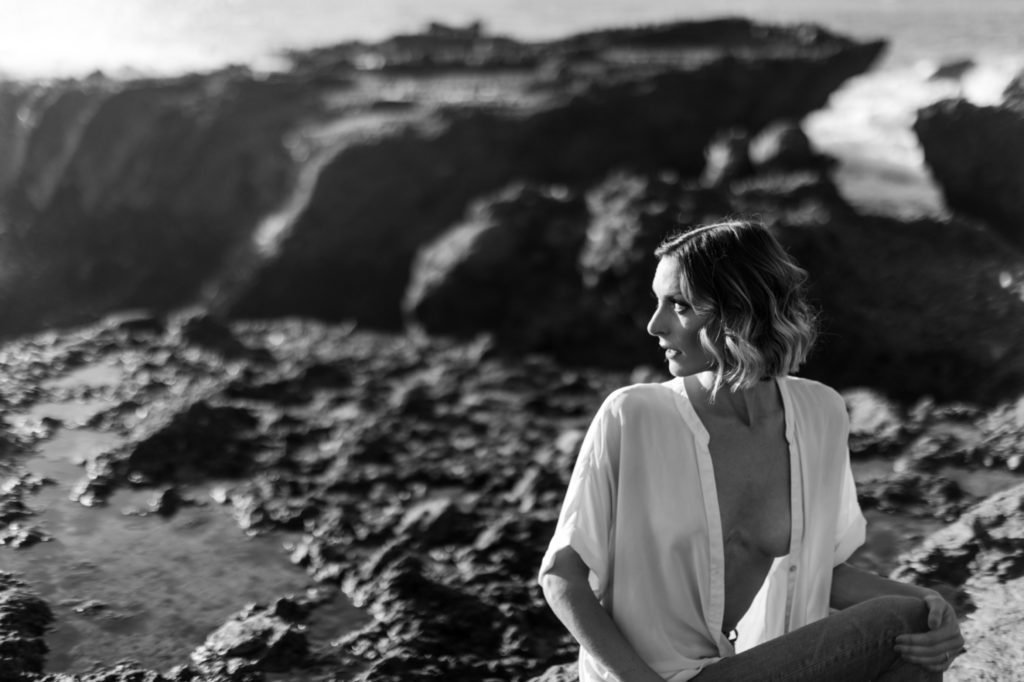 girl sitting on rocks for laguna beach boudoir session