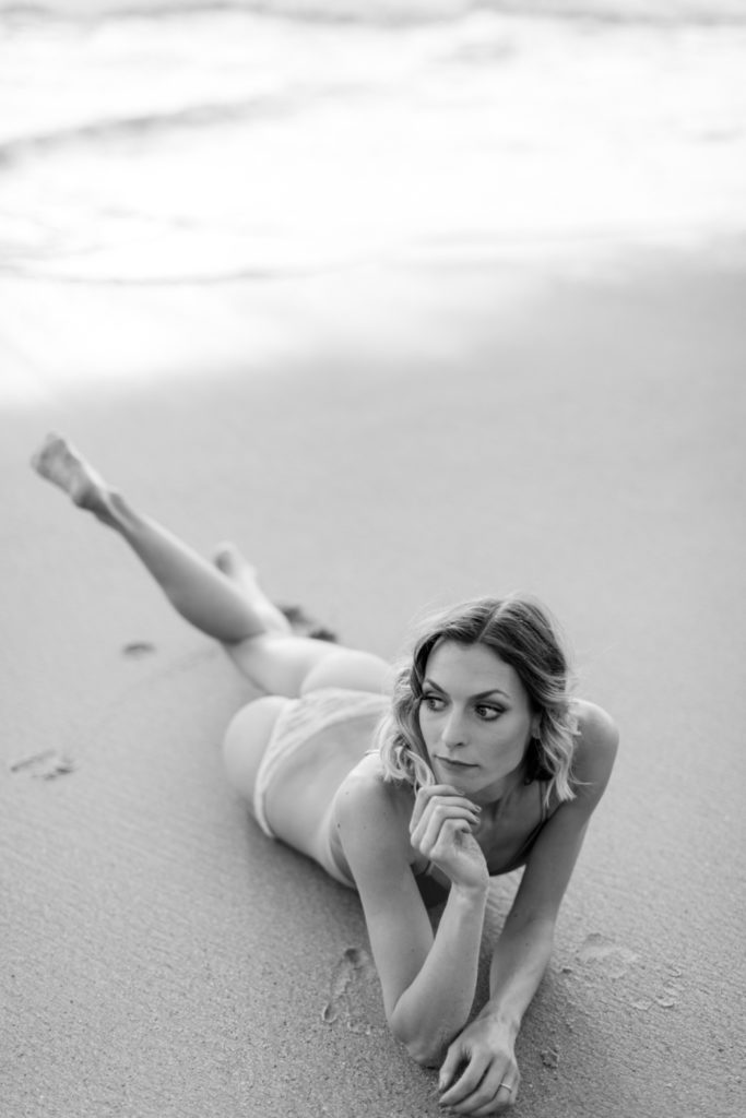 girl rolling in the sand for laguna beach boudoir session