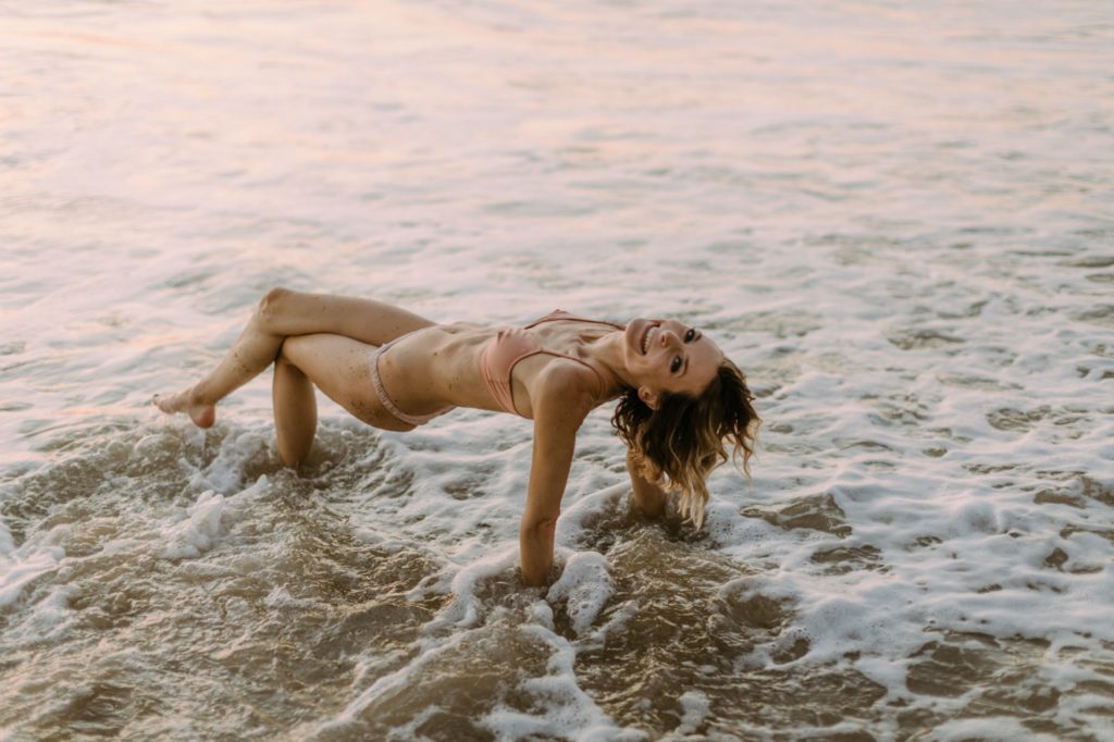girl jumping a wave for laguna beach boudoir session